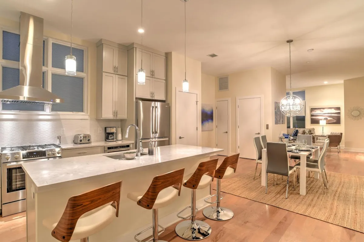 A spacious kitchen and dining area with an island countertop, modern appliances, and elegant lighting fixtures. The open-concept layout seamlessly connects cooking, dining, and entertaining spaces, supporting both casual breakfasts and festive dinner parties.